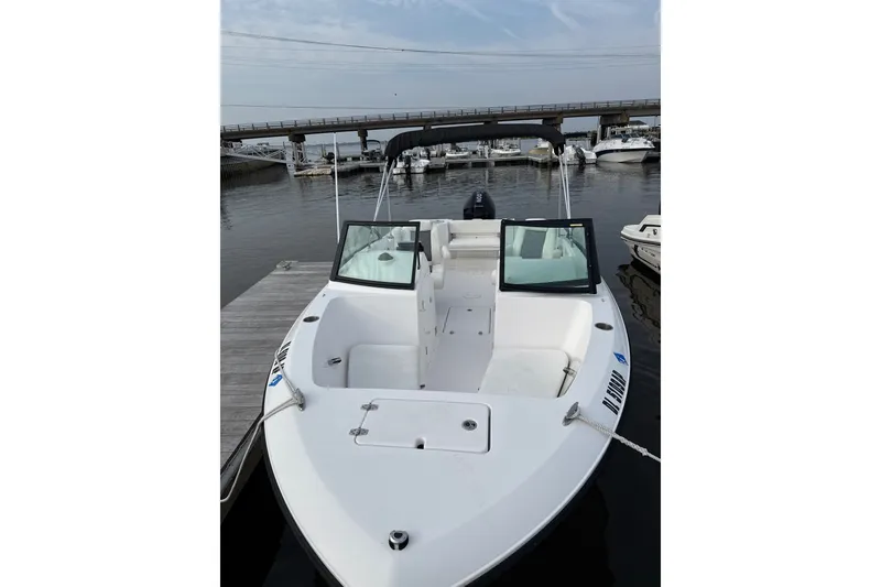 The Image of 2024 Aquasport 2200 Dual Console boat docked at marina, showcasing sleek design. - 1