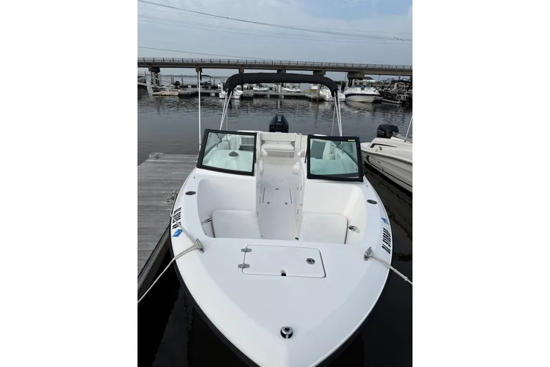 Slide: The Image of 2024 Aquasport 2200 Dual Console boat docked at marina, showcasing sleek design. - 2