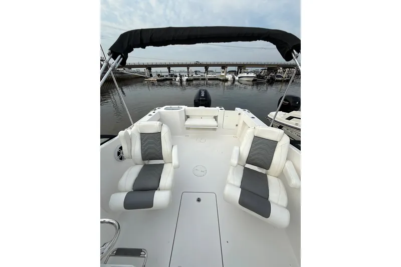 Slide: The Image of 2024 Aquasport 2200 Dual Console boat interior with seating, docked at marina. - 6