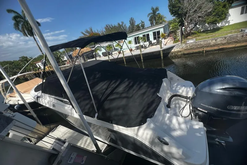 Slide: The Image of 2016 Robalo R227 Dual Console boat docked by a canal, covered and shaded. - 14