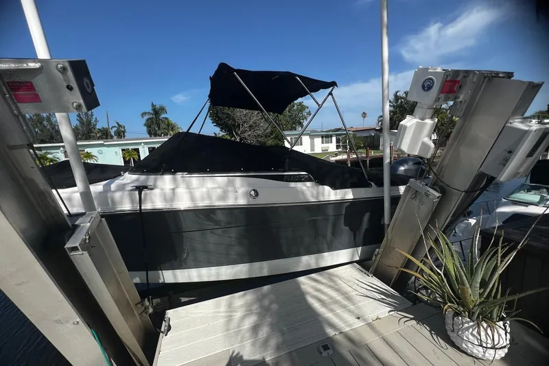 Slide: The Image of 2016 Robalo R227 Dual Console boat docked with cover, surrounded by tropical scenery. - 18