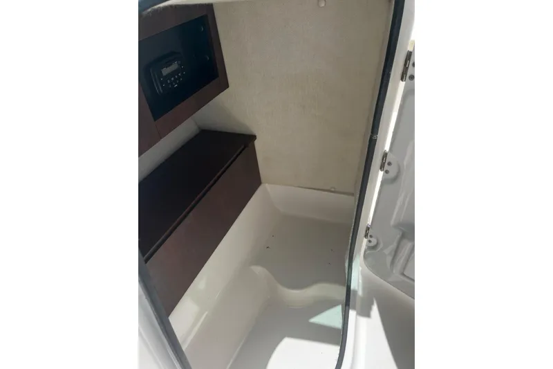 Slide: The Image of 2016 Robalo R227 Dual Console interior cabin with storage and radio. - 8