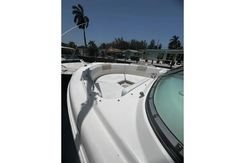 Slide: The Image of 2016 Robalo R227 Dual Console boat with spacious seating, docked near palm trees. - 5