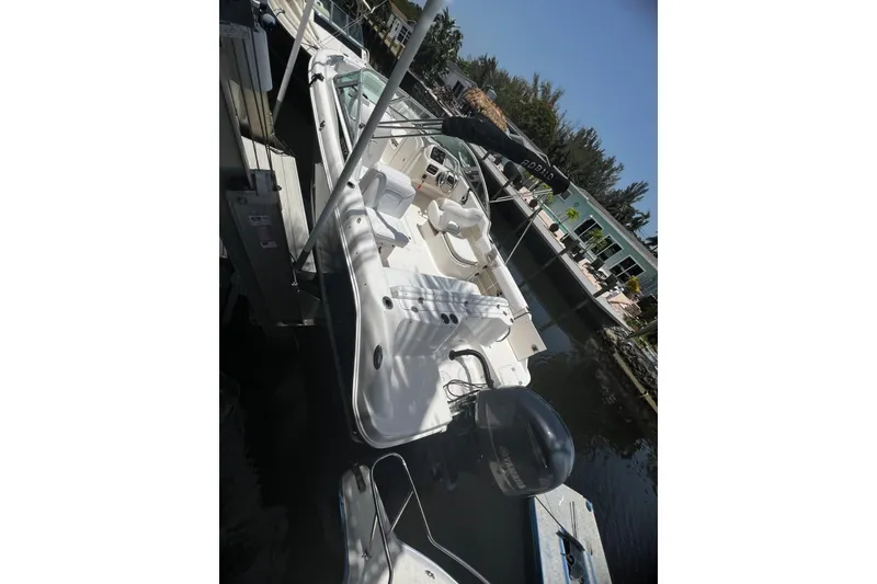 Slide: The Image of 2016 Robalo R227 Dual Console boat docked by waterfront homes. - 7