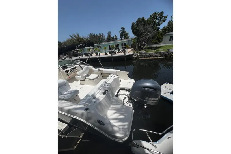 Slide: The Image of 2016 Robalo R227 Dual Console boat docked by a waterfront home. - 2