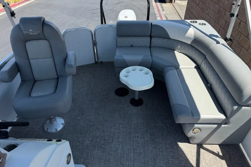 Slide: The Image of 2024 Lexington Emerg 17 Palm Breeze boat interior with gray seating and small table. - 14