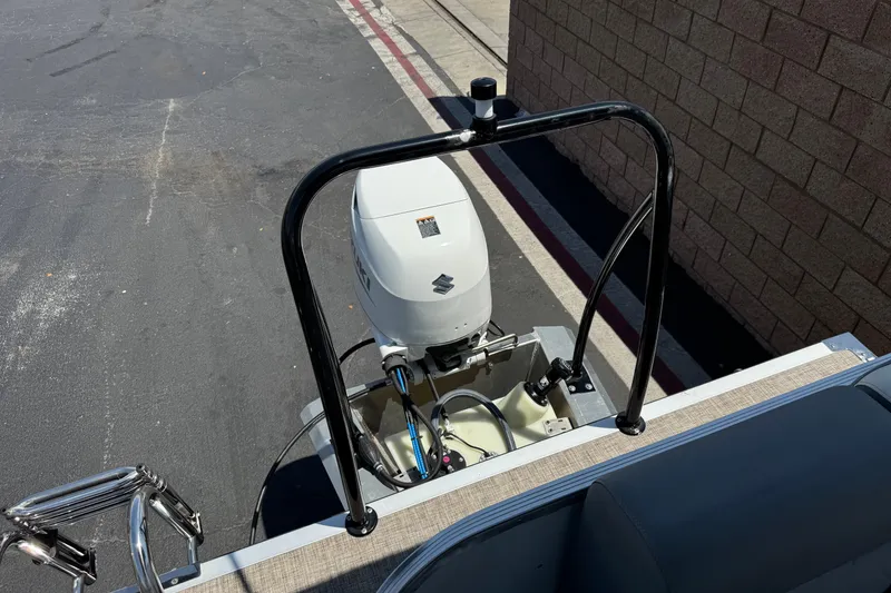 Slide: The Image of 2024 Lexington Emerg 17 Palm Breeze boat with Suzuki outboard motor in a parking area. - 18