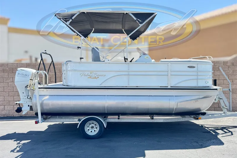 The Image of 2024 Lexington Emerg 17 Palm Breeze pontoon boat with Suzuki outboard motor on trailer. - 0