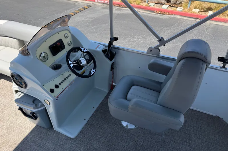 Slide: The Image of 2024 Lexington Emerg 17 Palm Breeze boat cockpit with steering wheel and captain's chair. - 19
