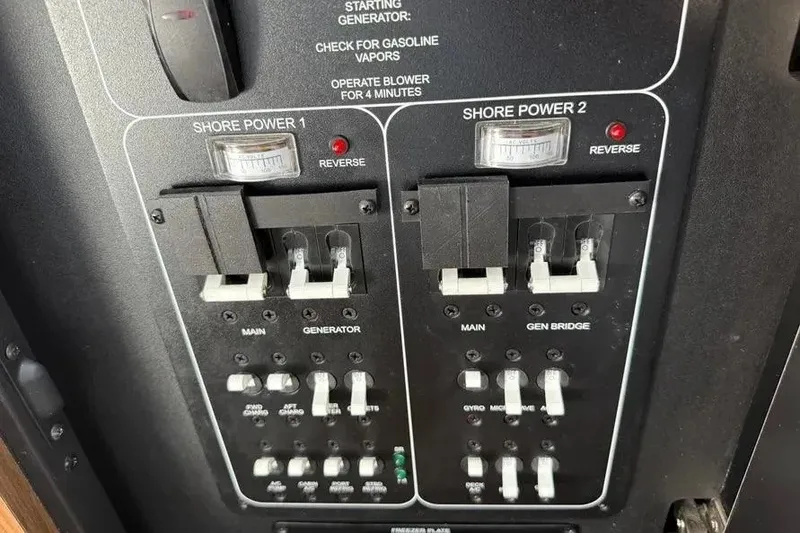 Slide: The Image of Electrical panel on a 2024 Boston Whaler 380 Outrage boat, featuring shore power controls. - 16