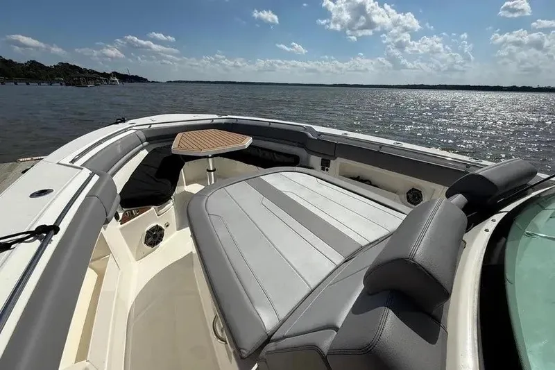 Slide: The Image of 2024 Boston Whaler 380 Outrage boat interior with seating and table on a sunny day. - 19