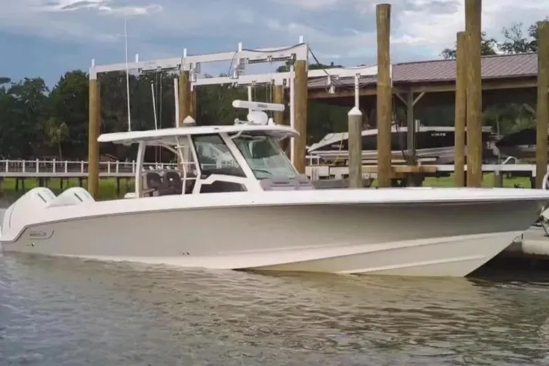 The Image of 2024 Boston Whaler 380 Outrage boat docked in a marina setting. - 1