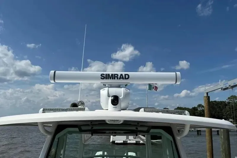 Slide: The Image of 2024 Boston Whaler 380 Outrage with Simrad radar, docked under a clear blue sky. - 17