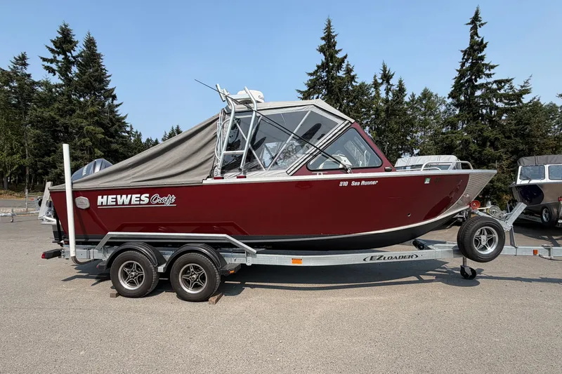 Slide: The Image of 2024 Hewescraft 210 Sea Runner ET boat on trailer, parked outdoors. - 19