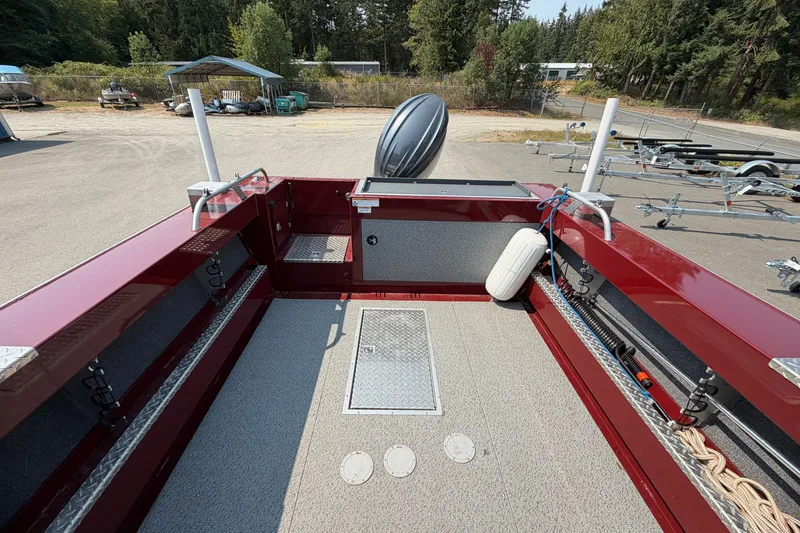 Slide: The Image of 2024 Hewescraft 210 Sea Runner ET boat deck with red railing and storage compartments. - 14