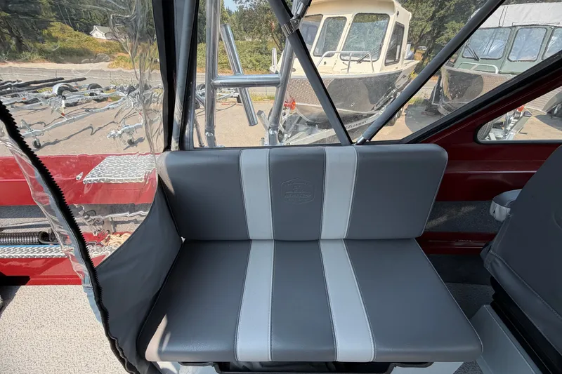 Slide: The Image of 2024 Hewescraft 210 Sea Runner ET interior seat with clear canopy and outdoor view. - 11