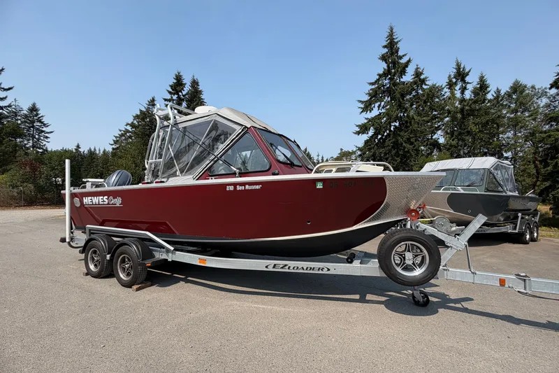 Slide: The Image of 2024 Hewescraft 210 Sea Runner ET boat on trailer, parked outdoors. - 1