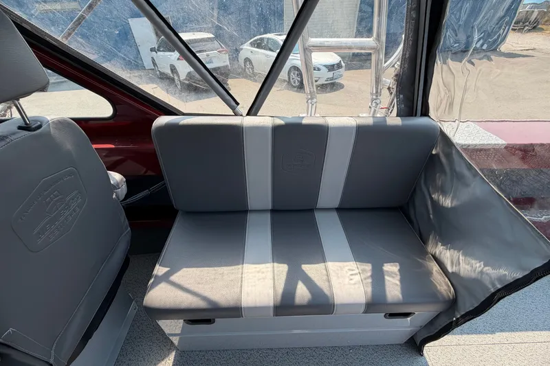 Slide: The Image of 2024 Hewescraft 210 Sea Runner ET interior with gray seating and window view. - 12
