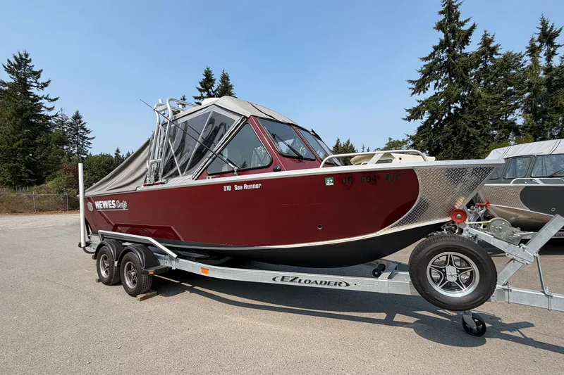 Slide: The Image of 2024 Hewescraft 210 Sea Runner ET boat on trailer, parked outdoors. - 16
