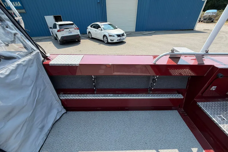 Slide: The Image of 2024 Hewescraft 210 Sea Runner ET boat interior with red accents and diamond plate flooring. - 15