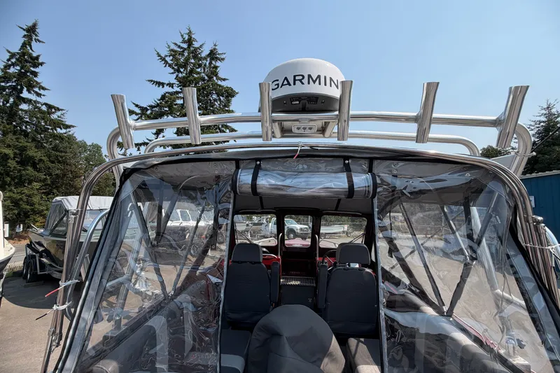 Slide: The Image of 2024 Hewescraft 210 Sea Runner ET boat with Garmin radar, clear canopy, and outdoor setting. - 2