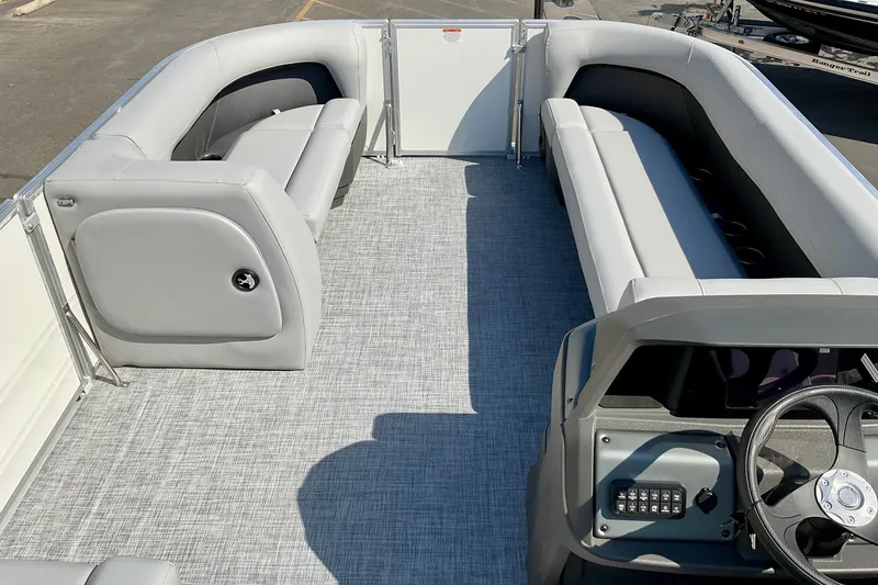 Slide: The Image of 2026 Sun Tracker Party Barge 18 DLX interior with gray seating and steering console. - 15