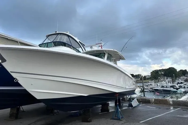 Slide: The Image of 2021 Boston Whaler 380 Outrage boat docked at marina under cloudy sky. - 3