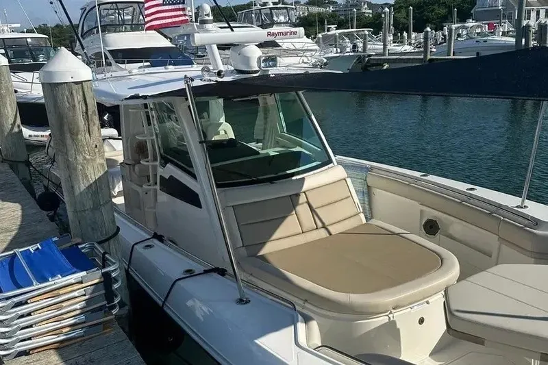 Slide: The Image of 2021 Boston Whaler 380 Outrage docked, featuring spacious seating and sleek design. - 7