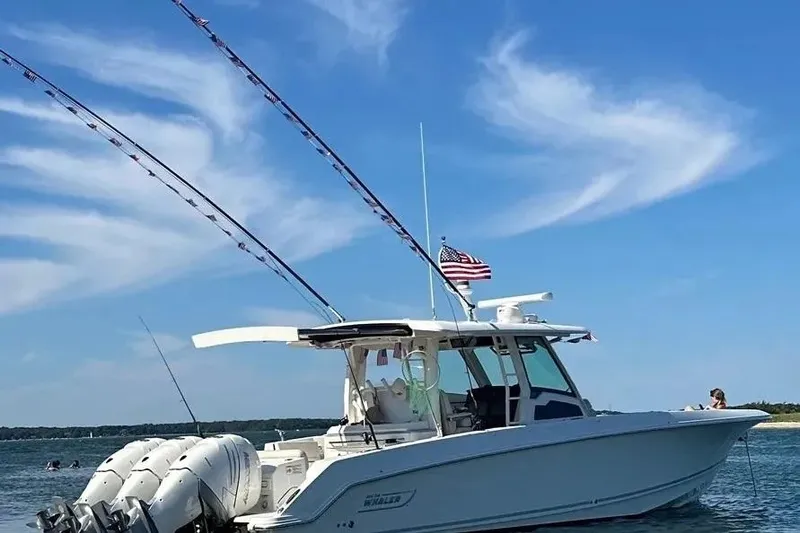 Slide: The Image of 2021 Boston Whaler 380 Outrage boat on water, clear sky, American flag flying. - 2