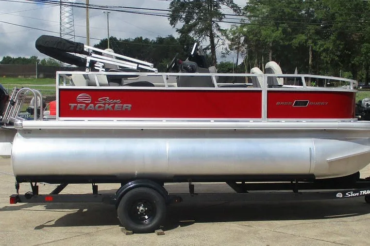 The Image of 2027 Sun Tracker Fishin' Barge 20 DLX pontoon boat on trailer, red and silver design. - 0