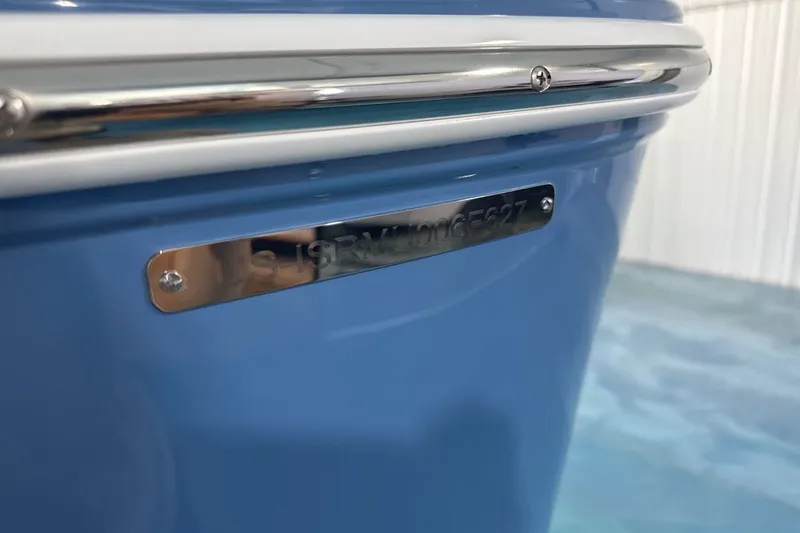 Slide: The Image of Close-up of a 2027 Moomba Max boat's blue hull with a metal identification plate. - 23