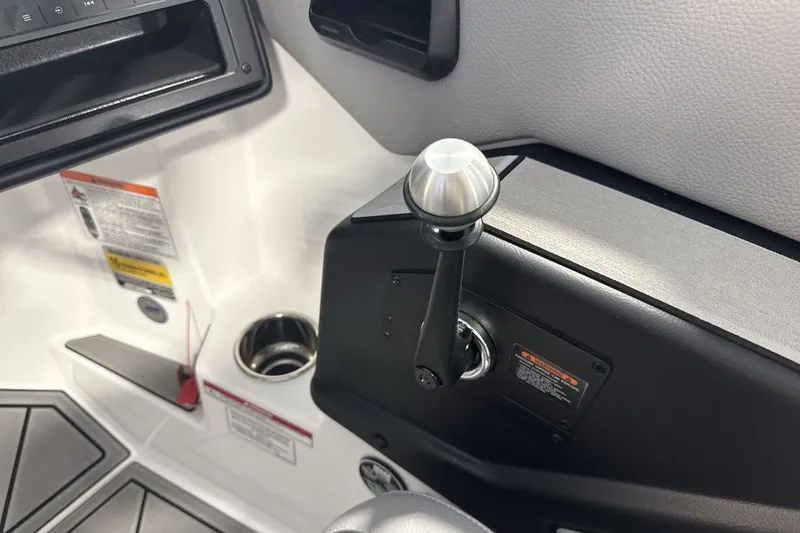 Slide: The Image of 2027 Moomba Max boat interior with control lever and cup holder. - 16