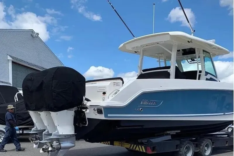 Slide: The Image of 2019 Boston Whaler 380 Outrage boat on trailer, featuring triple outboard engines. - 4