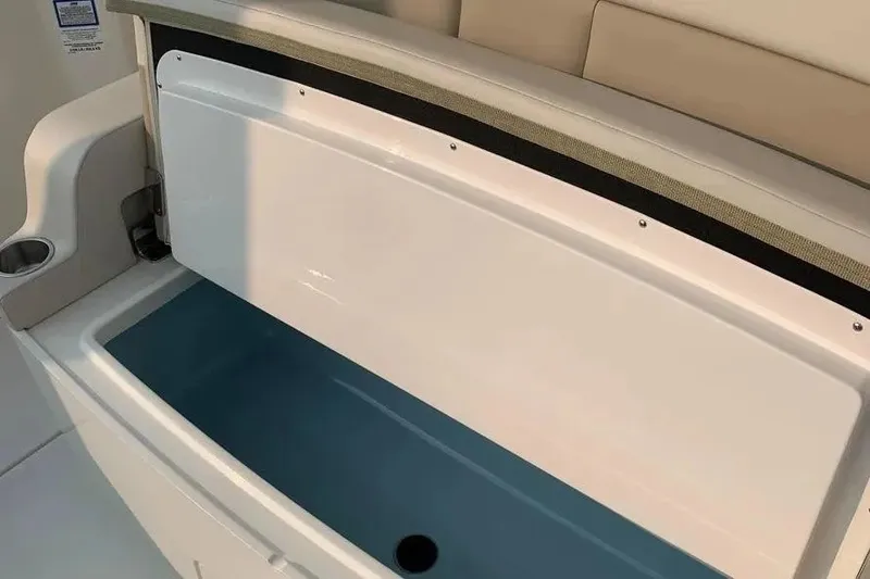 Slide: The Image of Open storage compartment on 2019 Boston Whaler 380 Outrage boat, featuring sleek design and cup holder. - 20
