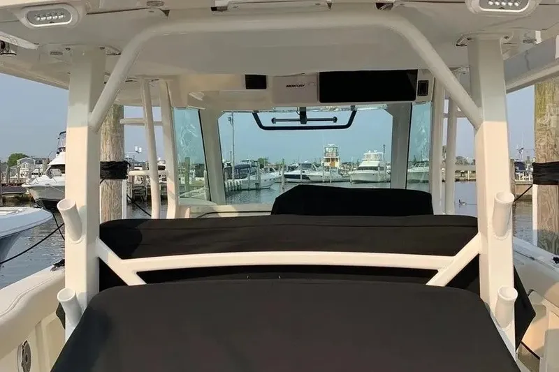 Slide: The Image of 2019 Boston Whaler 380 Outrage interior view at marina, showcasing helm and seating. - 45