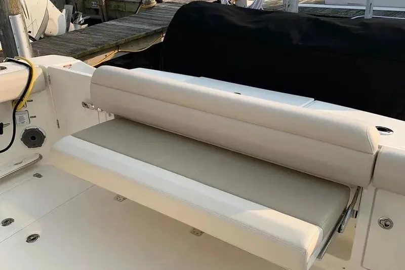 Slide: The Image of 2019 Boston Whaler 380 Outrage boat seating area with beige cushions. - 50