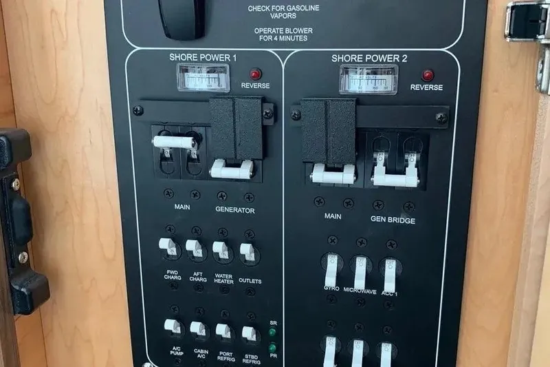 Slide: The Image of Electrical panel on a 2019 Boston Whaler 380 Outrage boat, featuring shore power controls. - 52