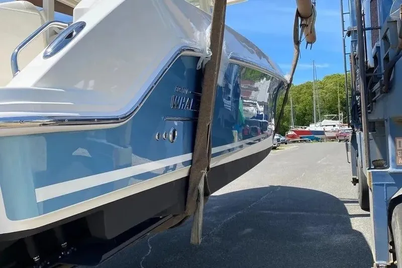 Slide: The Image of 2019 Boston Whaler 380 Outrage boat being lifted, showcasing sleek blue hull design. - 5