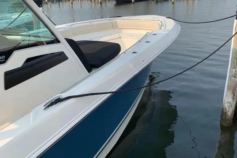Slide: The Image of 2019 Boston Whaler 380 Outrage docked, showcasing sleek design and spacious deck. - 15