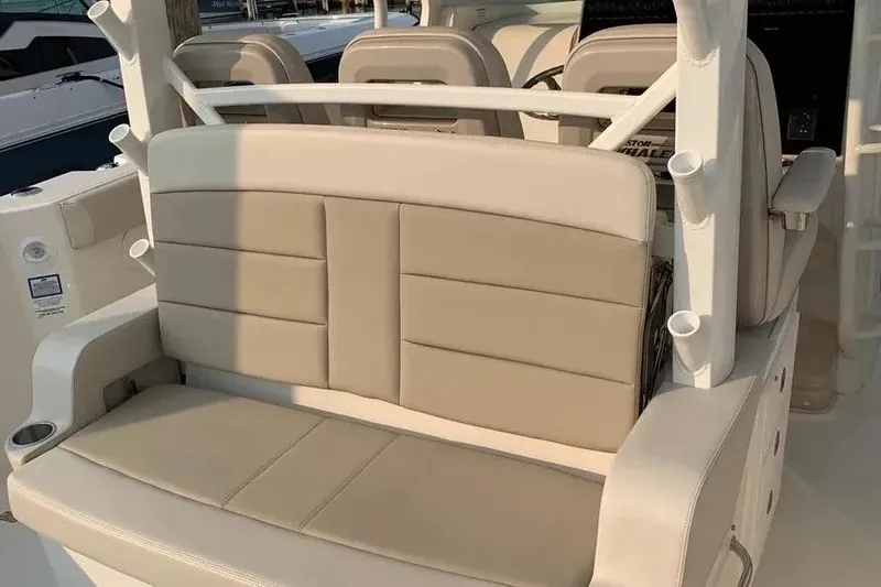 Slide: The Image of 2019 Boston Whaler 380 Outrage boat seating area with beige upholstery and cup holders. - 18