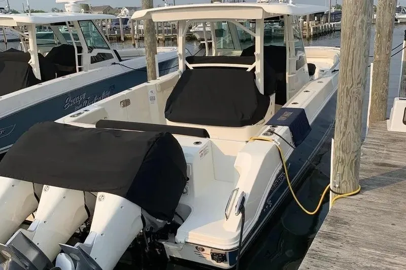 Slide: The Image of 2019 Boston Whaler 380 Outrage docked, featuring covered engines and sleek design. - 40