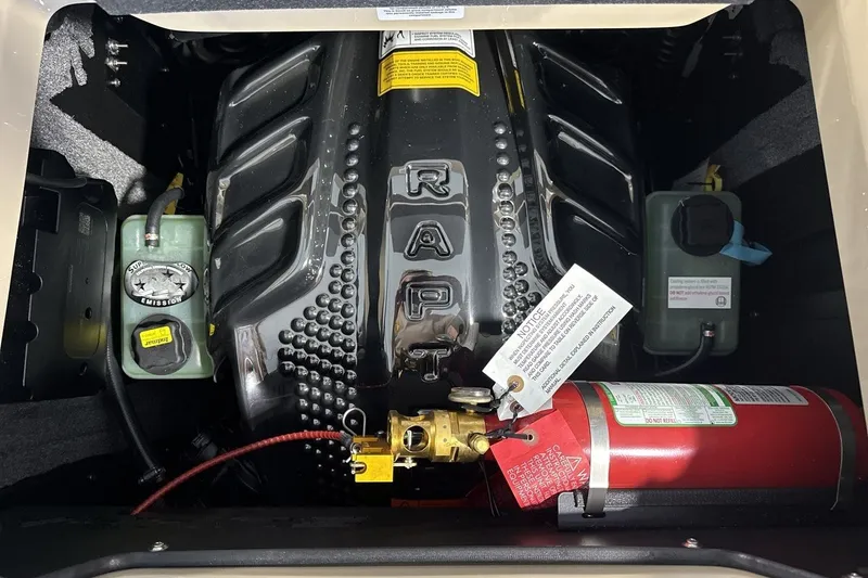 Slide: The Image of Engine compartment of a 2027 Supra SL 550 with visible components and fire extinguisher. - 56