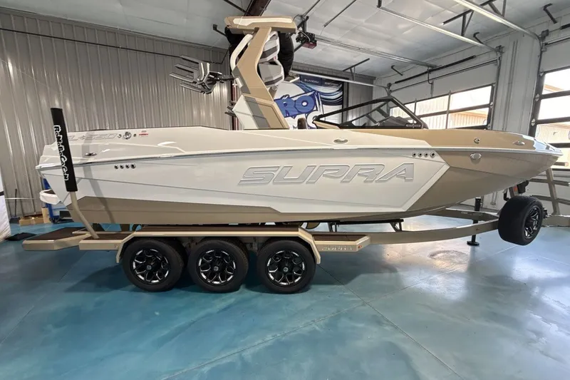 Slide: The Image of 2027 Supra SL 550 boat on trailer in showroom setting. - 42