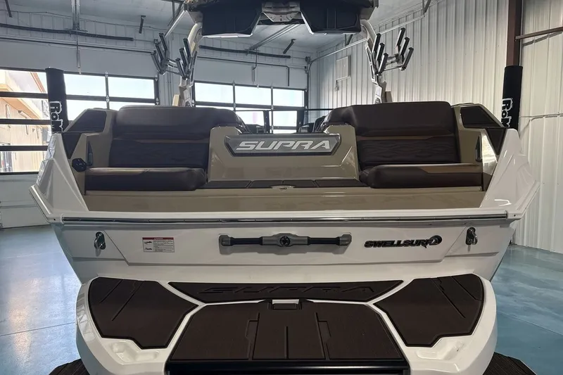 Slide: The Image of 2027 Supra SL 550 boat interior with brown seating in a garage setting. - 40