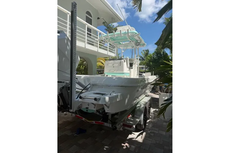 Slide: The Image of 2023 Caymas 281 HB boat parked on a trailer near a modern house. - 8
