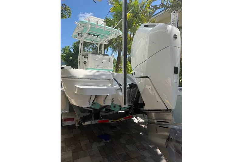 Slide: The Image of 2023 Caymas 281 HB boat with powerful outboard motor, parked under sunny skies. - 9