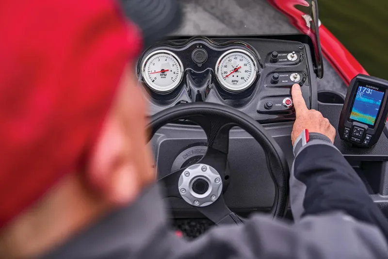 Slide: The Image of Manufacturer Provided Image: Person operating 2026 Tracker Super Guide V-16 SC boat dashboard with gauges and controls. - 43