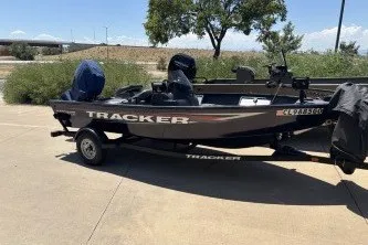 The Image of 2026 Tracker Super Guide V-16 SC boat on trailer, parked outdoors. - 0