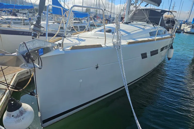 The Image of 2022 Jeanneau Sun Odyssey 349 Performance sailboat docked in marina, showcasing sleek design. - 1