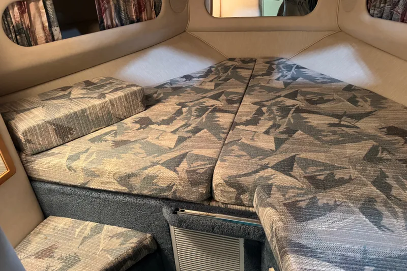 Slide: The Image of 1994 Sea Ray 300 Sundancer cabin interior with patterned cushions and cozy sleeping area. - 14
